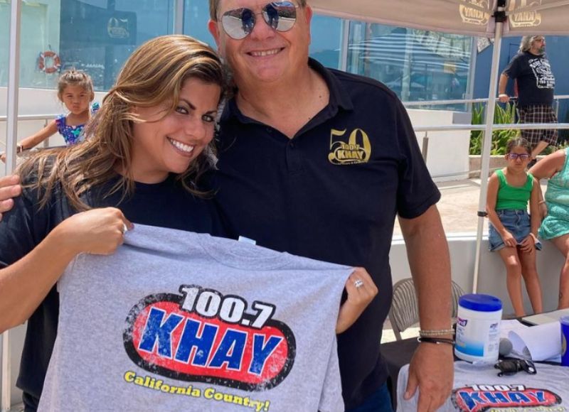 Country muysic fan holding khay country music shirt with host dave daniels