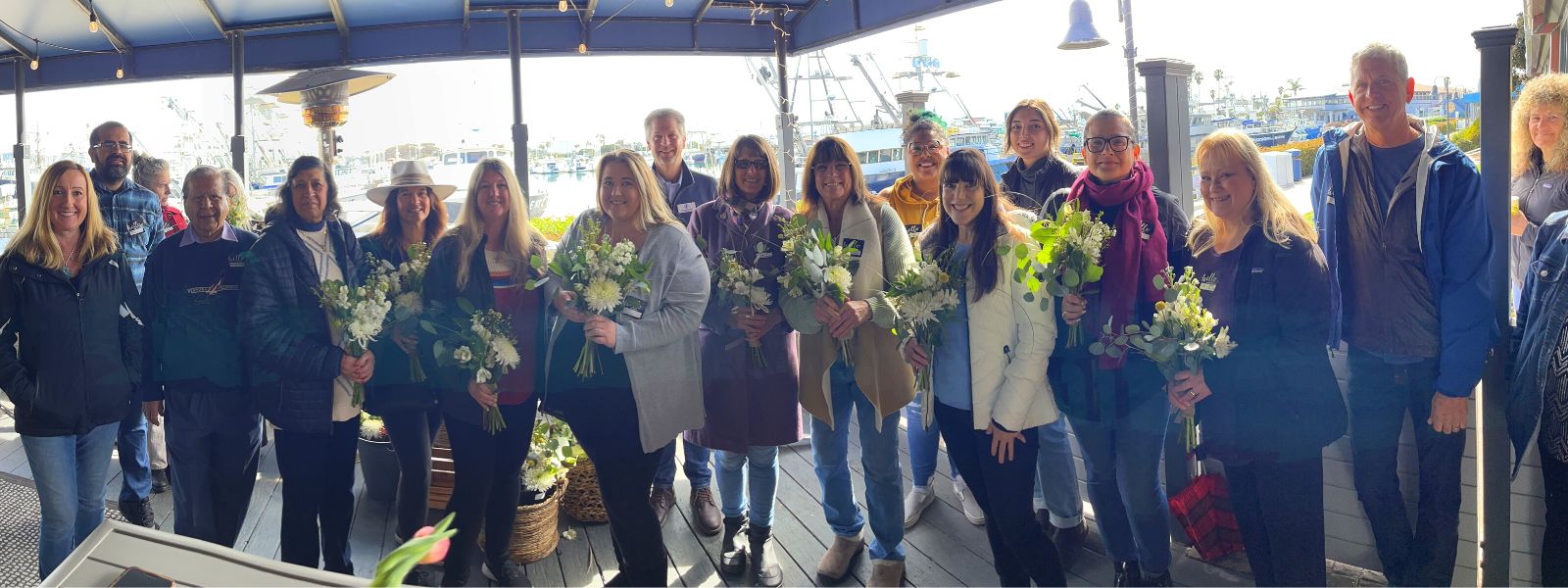Group of business owners and representatives holding flowers