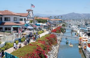 view of ventura harbor village shops and marina with boats