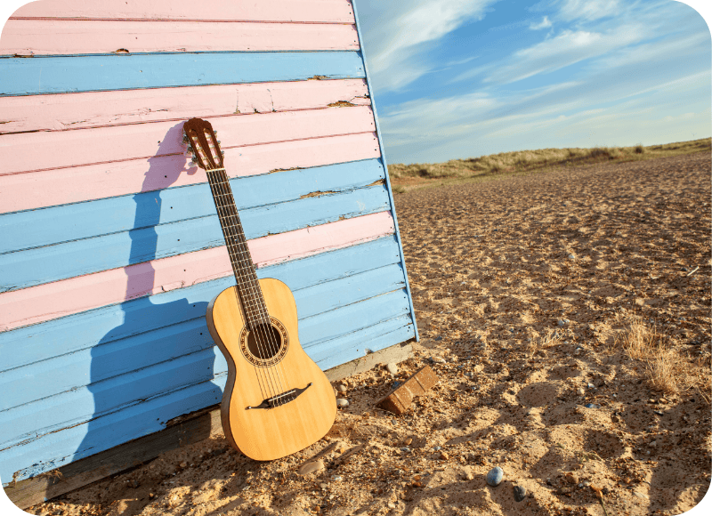 Acoustic guitar leaning against a colorful beach hut at Ventura Harbor Village.