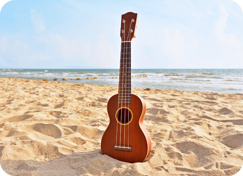 Ukulele on Ventura Harbor Beach with ocean and sky in background.