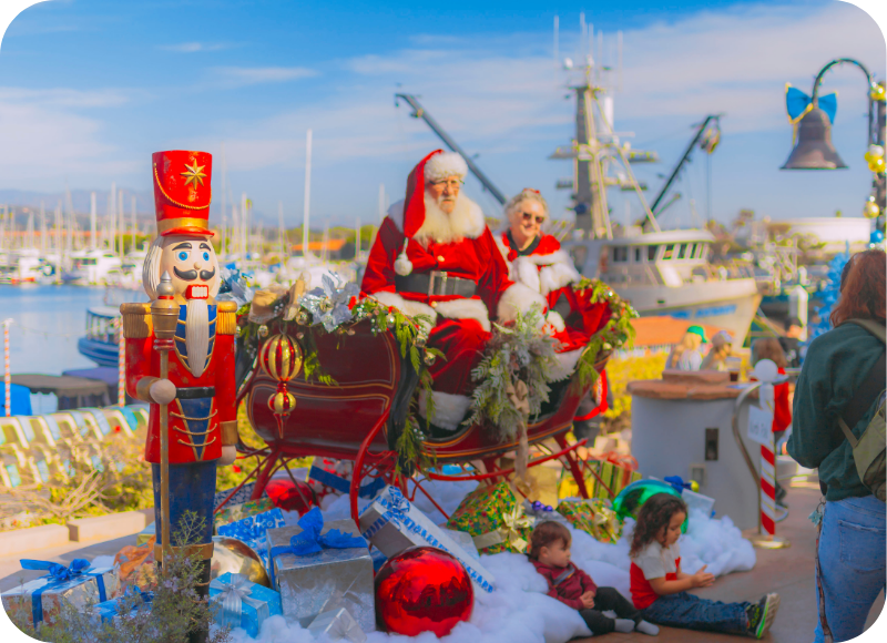 Santa Claus and Mrs. Claus in a boat at Ventura Harbor Village during winter festivities.