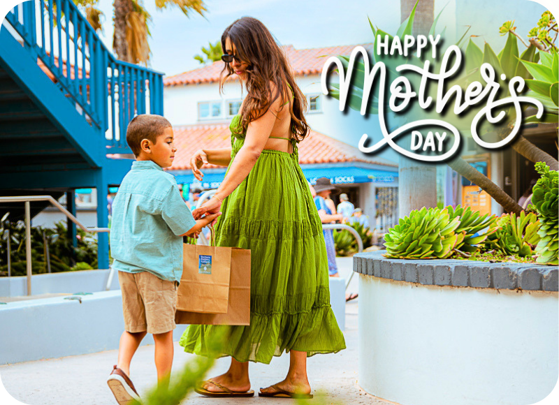 Mother and child exchanging gifts at Ventura Harbor Village for Mother's Day.