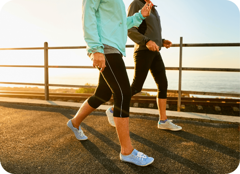 Women walking along a waterfront promenade during sunset at Ventura Harbor Village.