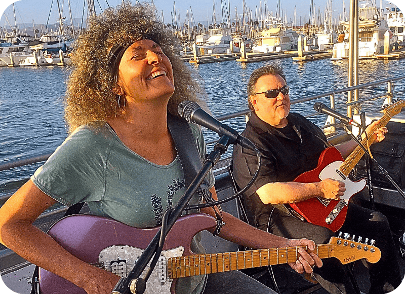Live music performance at Ventura Harbor Village with two guitarists by the marina.