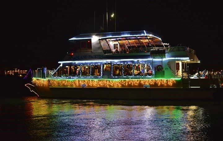 Nighttime Ventura Harbor Village boat decorated with holiday lights and ornaments.